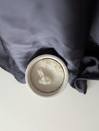 Bougie artisanale parfumée vue du dessus avec cire délicate et composition pour annonce grossesse, naissance, bébé montrant trois étoiles, un nounours et un nuage.