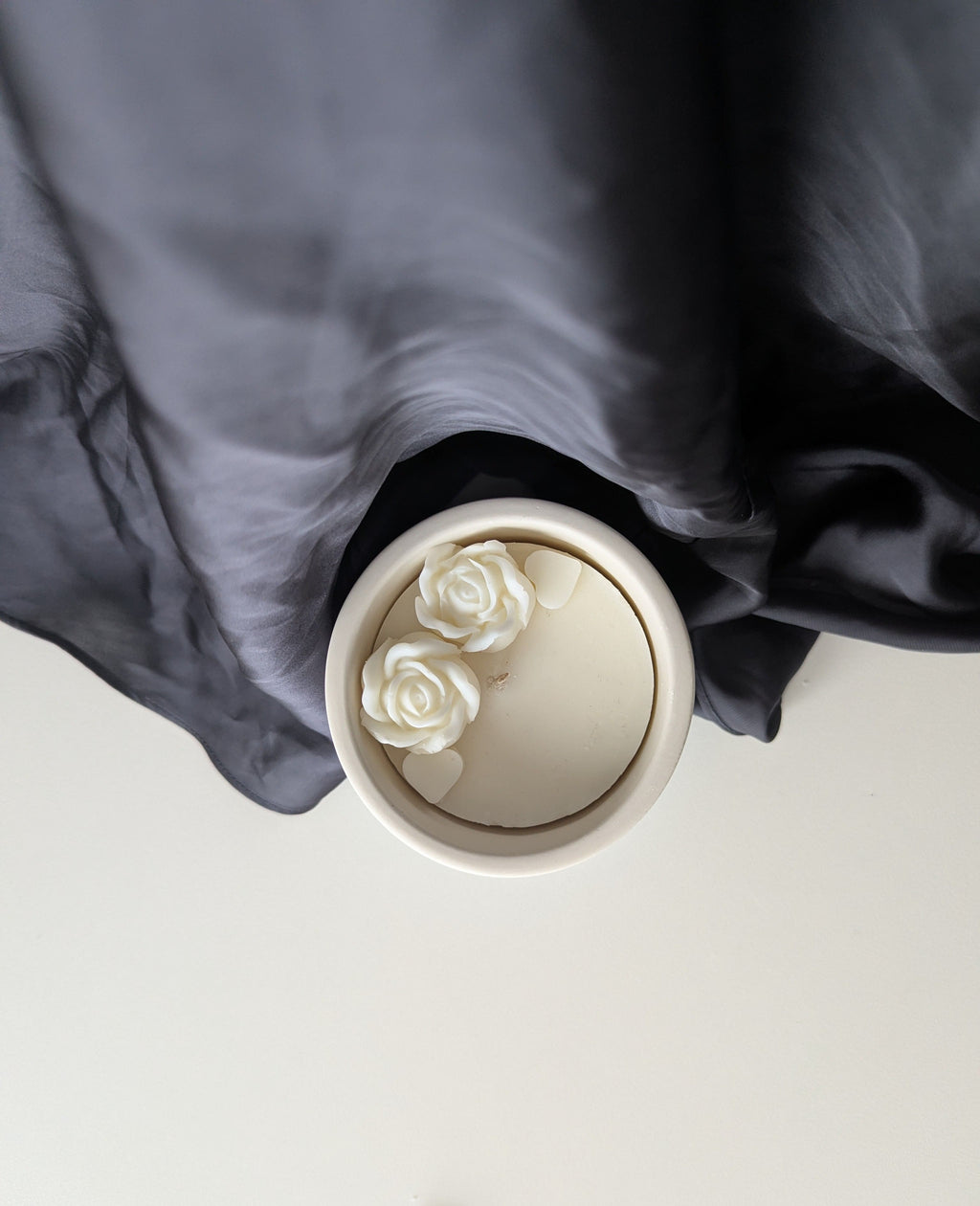 Bougie artisanale parfumée vue du dessus avec cire délicate et composition élégante de duo de fleurs et de cœurs 