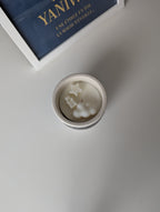 Bougie artisanale parfumée vue du dessus avec cire délicate et composition pour annonce grossesse, naissance, bébé montrant une étoile, un nounours et un nuage