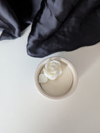Bougie artisanale parfumée vue du dessus avec cire délicate et composition élégante d’une fleur et d’un cœur  