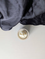 Bougie artisanale parfumée vue du dessus avec cire végétale délicate et composition annonce bébé, grossesse avec un nuage
