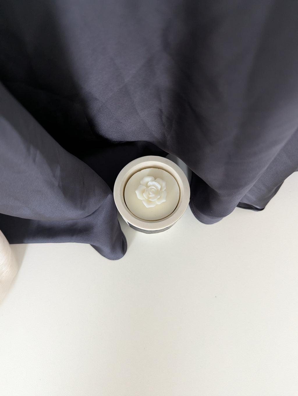 Bougie artisanale parfumée vue du dessus avec cire délicate et composition élégante d’une fleur