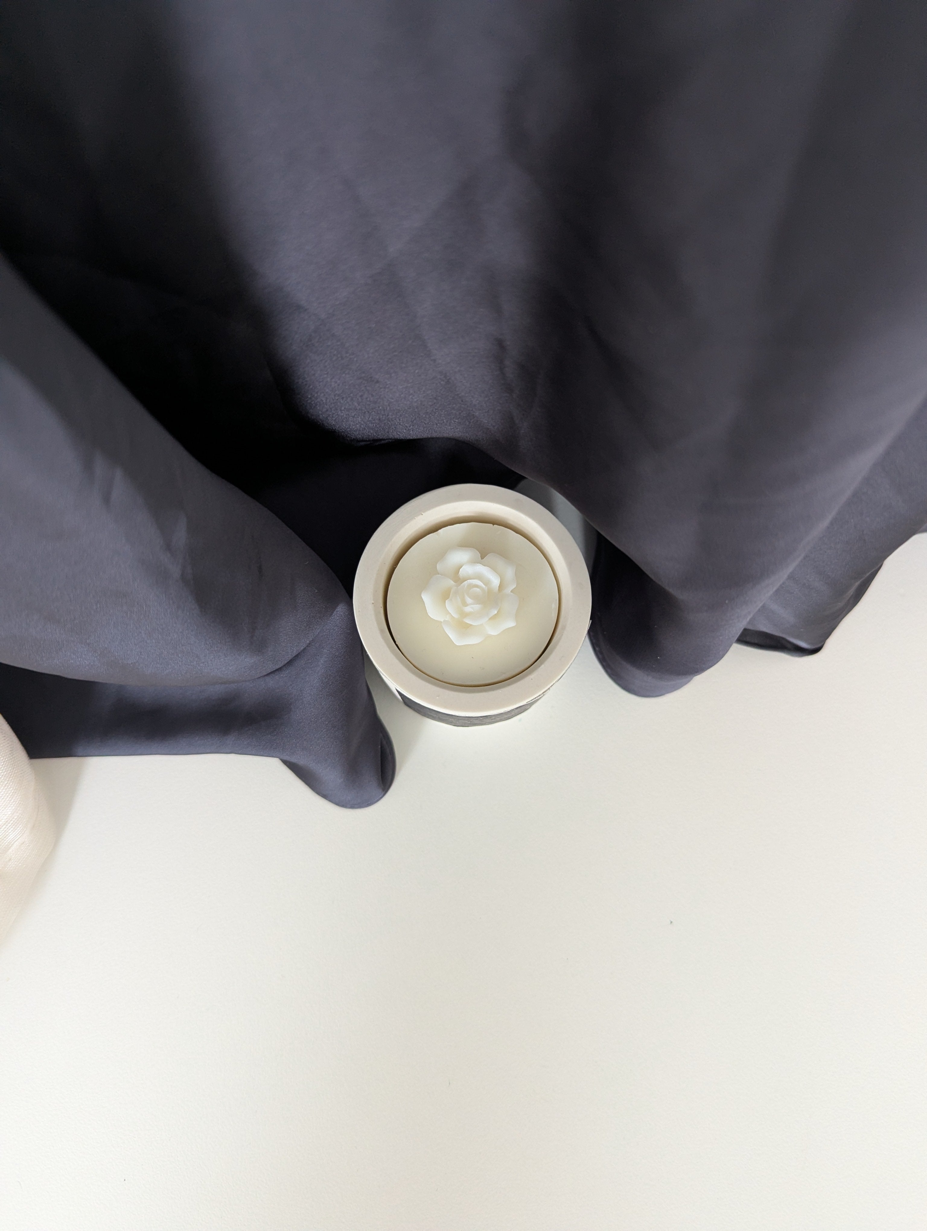 Bougie artisanale parfumée vue du dessus avec cire délicate et composition élégante d’une fleur